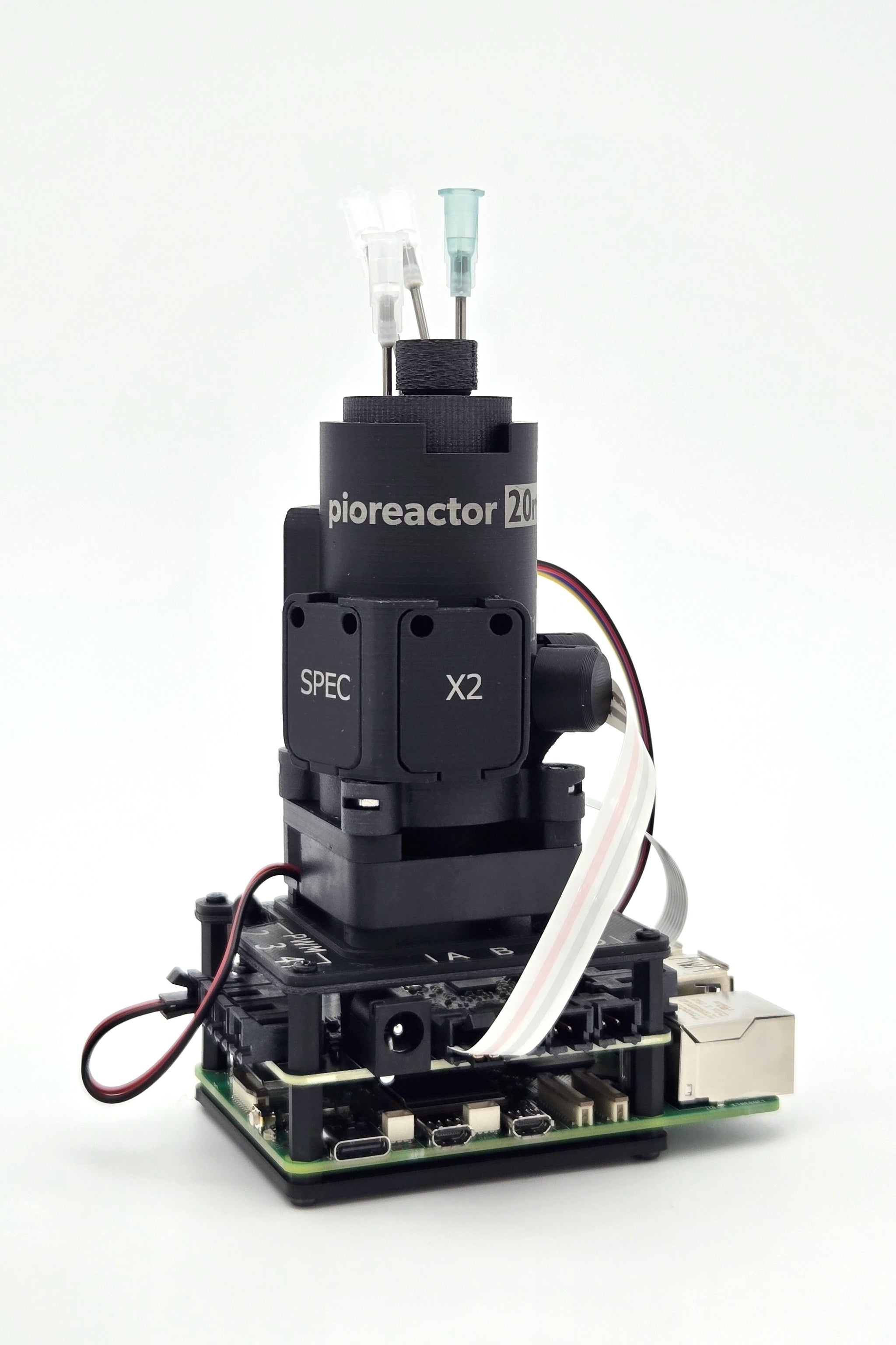Pioreactor 20 ml v1.5 z naczyniem, optyką Eye-Spy i Raspberry Pi. Widoczne porty służą do zbudowania toru cieczowego; sam reaktor nie zawiera w podstawowej konfiguracji wszystkich pomp potrzebnych do chemostatu. Fotografia producenta udostępniona w karcie Pioreactor 20 ml w serwisie Bioreaktory.